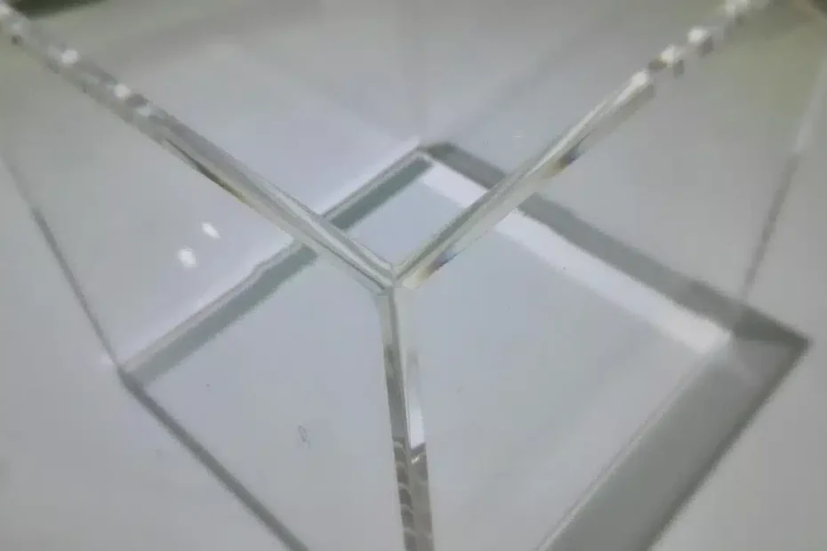 Photo de façonnage: coin jointé en PMMA transparent avec angles nets, montrant des pièces en plexiglass usinées.